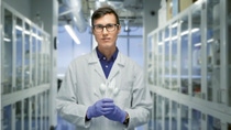 Frontalaufnahme eines Wissenschaftlers in seinem Labor, welches Plastikbesteck in seinen Händen hält. Frontalaufnahme eines Wissenschaftlers in seinem Labor, welches Plastikbesteck in seinen Händen hält.
