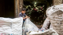 Müllsammler, auf den Straßen von Kairo, der einen Plastiksack zubindet. Müllsammler, auf den Straßen von Kairo, der einen Plastiksack zubindet.