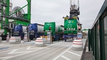 The photo shows a logistics facility where tank containers are being moved. The photo shows a logistics facility where tank containers are being moved.