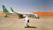 Eine Person läuft über eine Start- und Landebahnen zum Flugzeug in Saudi Arabien. Eine Person läuft über eine Start- und Landebahnen zum Flugzeug in Saudi Arabien.
