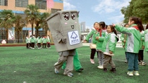 Ein Mülltonnenmaskottchen erklärt kleinen Kindern in China, wie wichtig Recycling für die Erde ist. Ein Mülltonnenmaskottchen erklärt kleinen Kindern in China, wie wichtig Recycling für die Erde ist.
