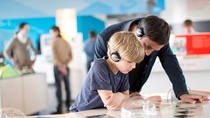 A man and a boy with headphones visit an exhibition A man and a boy with headphones visit an exhibition