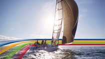 People on a sailing boat in the ocean, under a bright sky, surrounded by a key visual of four lines in blue, orange, green and red (photoshopped) People on a sailing boat in the ocean, under a bright sky, surrounded by a key visual of four lines in blue, orange, green and red (photoshopped)