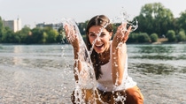 Carefree young woman refreshing in water of a river Carefree young woman refreshing in water of a river
