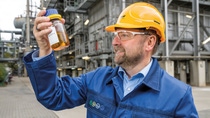 A BASF colleague with a bottle of pyrolysis oil recovered from plastic waste A BASF colleague with a bottle of pyrolysis oil recovered from plastic waste