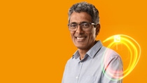 A BASF employee stands against an orange background, smiling at the camera, with glowing light trails in front of him. A BASF employee stands against an orange background, smiling at the camera, with glowing light trails in front of him.