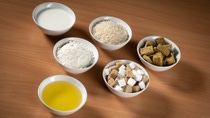 Bowls with oil, milk, flour, rice, sugar and stock cubes Bowls with oil, milk, flour, rice, sugar and stock cubes