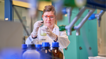 A woman in a lab stirring a liquid in a beaker. A woman in a lab stirring a liquid in a beaker.