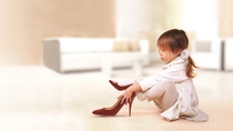 Mignonne petite fille essayant sur les talons rouges Mignonne petite fille essayant sur les talons rouges