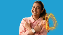 A smiling BASF employee in a pink shirt stands against a blue background, crossing her arms and pointing to the side, with glowing light trails. A smiling BASF employee in a pink shirt stands against a blue background, crossing her arms and pointing to the side, with glowing light trails.