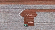 The picture is an aerial view of a cotton field, where a harvesting machine is working. The soil showing where the cotton has been harvested is in the shape of a T-shirt. There are white handwritten sketches on the picture showing scientific formulae and three arrows.  The picture is an aerial view of a cotton field, where a harvesting machine is working. The soil showing where the cotton has been harvested is in the shape of a T-shirt. There are white handwritten sketches on the picture showing scientific formulae and three arrows.