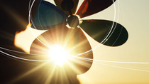 A silhouette image of a child with a rainbow coloured pinwheel, looking at the sunset setting on the horizon, with sketch lines showing the path of the wind over her pinwheel. A silhouette image of a child with a rainbow coloured pinwheel, looking at the sunset setting on the horizon, with sketch lines showing the path of the wind over her pinwheel.