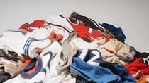 Une pile de maillots de sport usagés de différentes couleurs.  Une pile de maillots de sport usagés de différentes couleurs.