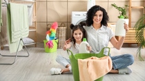 Mother and daughter are sitting in the bathroom, around them are cleaning products. Mother and daughter are sitting in the bathroom, around them are cleaning products.