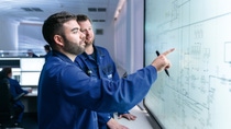 Two IT experts, like developer, data engineer or IT consultant, standing in front of a big display at the BASF location Ludwigshafen. Two IT experts, like developer, data engineer or IT consultant, standing in front of a big display at the BASF location Ludwigshafen.
