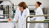 Two female scientists in a BASF lab/chemical laboratory, both wearing lab coats and protective eyewear. Two female scientists in a BASF lab/chemical laboratory, both wearing lab coats and protective eyewear.
