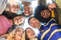 A diverse group of people put their hands over each other with motivation. A diverse group of people put their hands over each other with motivation.