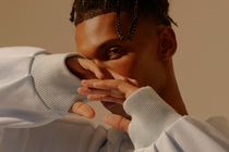 A man posing with his hands slightly in front of his face. A man posing with his hands slightly in front of his face.