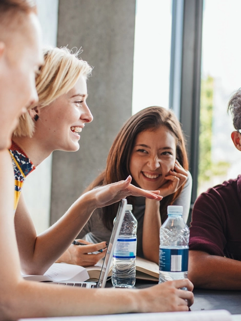 University students sitting together at table with books and laptop. Happy young people doing group study in library.; Shutterstock ID 508251865