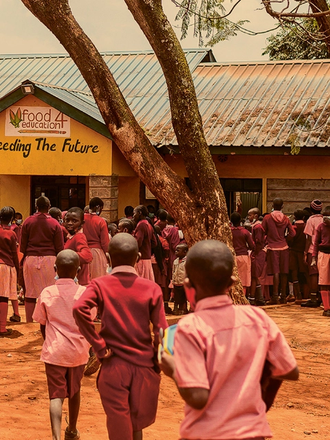 Students line up to pick up their lunch from the Food4Education kitchen.