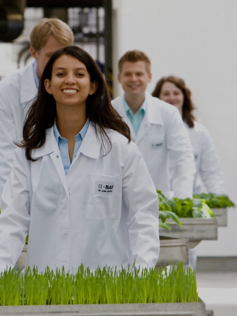 A smiling young woman in laboratory clothing.