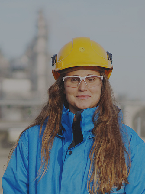 Eine Ingenieurin mit Schutzhelm und Schutzbrille steht vor einer Industrieanlage. Sie arbeitet an nachhaltigen chemischen Innovationen. Eine Ingenieurin mit Schutzhelm und Schutzbrille steht vor einer Industrieanlage. Sie arbeitet an nachhaltigen chemischen Innovationen.