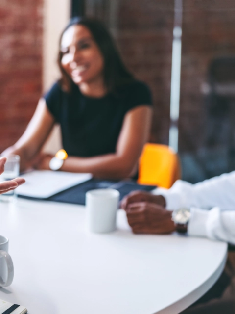 Businessman leading a meeting in a modern office. Experienced mature businessman briefing his colleagues in a meeting room. Group of creative businesspeople working as a team.