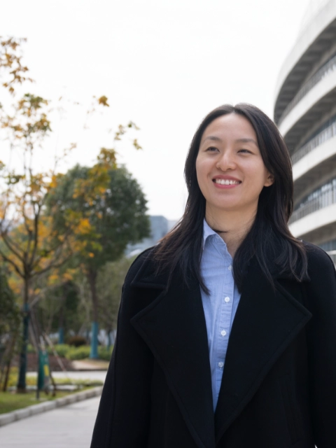 A woman walking towards the camera and smiling