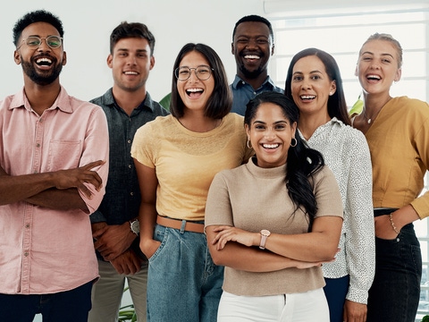 A group of young talents stand in a bright office room and smile at the camera. A group of young talents stand in a bright office room and smile at the camera.