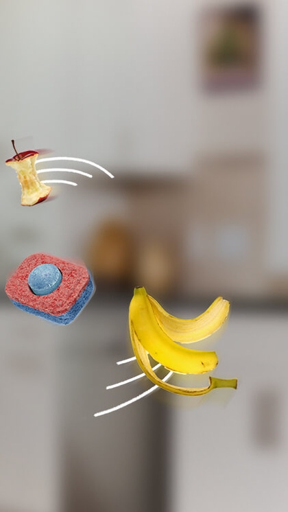 A banana, an apple core and a leaf spinning around a dishwasher tablet A banana, an apple core and a leaf spinning around a dishwasher tablet