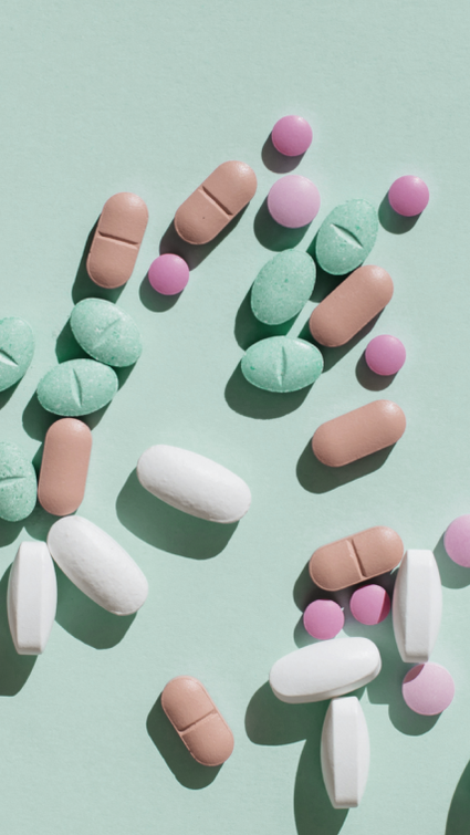 Many colourful pills scattered on a green surface. Many colourful pills scattered on a green surface.