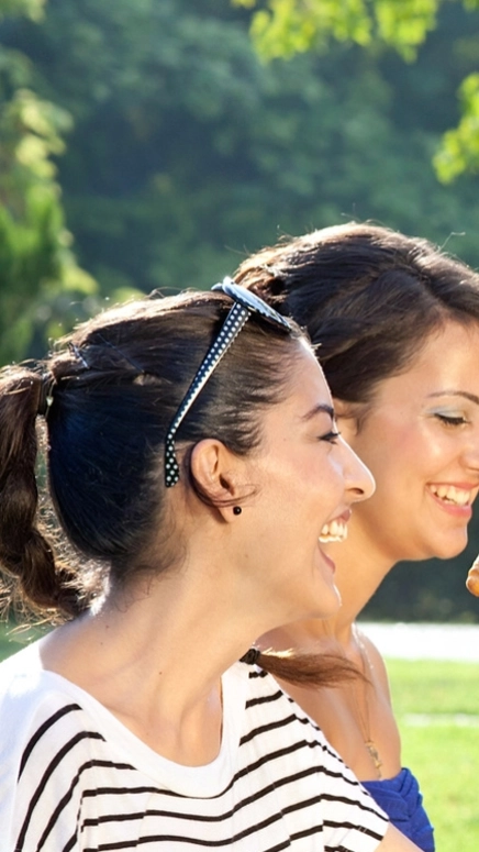 Group of people laughing and having a picnic cheer-sing cups 