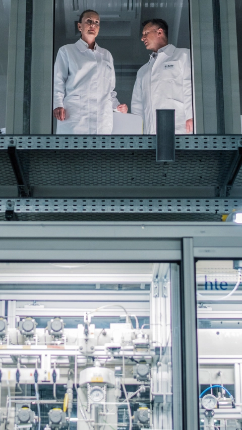 The pilot plant facility houses highly automated experimental facilities for efficient process development and testing of new process catalysts, e.g. for gas-phase hydrogenation or catalyst testing. Operations manager assistant Dirk Boehm (right) talking to chemical laboratory assistants Patrick Graneß (left) and Melanie Zier (center). 