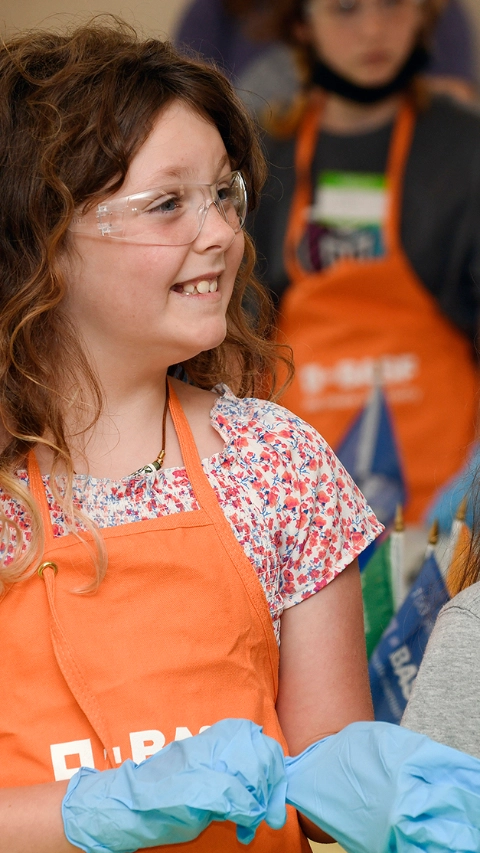 Girls smiling and participating of a Kids' Lab experiment