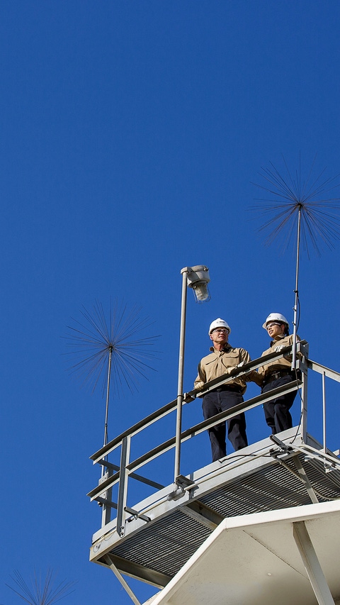 Ricky Bolyard (links) und Samantha Briggs (rechts), beide Prozesstechniker, besprechen ihre Arbeit auf dem Regenwassertank in Port Arthur, Texas. Das gesammelte Regenwasser des Tanks wird aufbereitet und gereinigt bevor es in der Produktion genutzt wird.