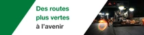 Des travaux sur la route la nuit avec des travailleurs et des machines. Un tourbillon de lumière flotte sur la scène. Le texte indique : « Des routes plus vertes nous attendent. » Des travaux sur la route la nuit avec des travailleurs et des machines. Un tourbillon de lumière flotte sur la scène. Le texte indique : « Des routes plus vertes nous attendent. »